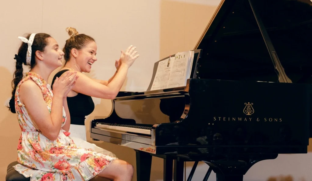 Piano teacher Claudia from Oohlala Fine Arts instructing a student during a music lesson.