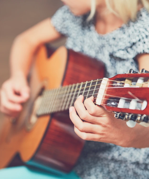 girl learning to play to the guitar