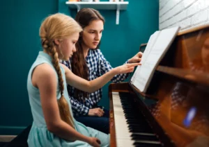 Piano teacher giving a music lesson to her student.